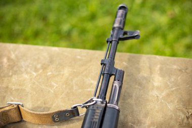 Otomatik silah parçaları. Makineli tüfek namlusu. Eğitim silahı masanın üstünde. Askeri eğitimin ayrıntıları.