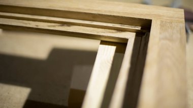 Çerçeve açısı. Çiğ odun. İçsel ayrıntılar oluşturmak için tahtaları inceliyorum. Marangozluk atölyesindeki tahtalar. Mobilya oluşturma.