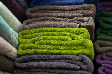 Havlular istiflendi. Banyo için havlu. Kumaştan yapılmış şeyler rafta düz duruyor..