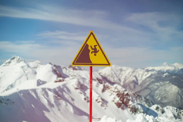 山の背景にサインインします 落下の危険性の警告に署名します 三角形の棒 黄色の背景のシンボル 慎重に突然の休憩 深淵に陥る可能性 — ストック写真