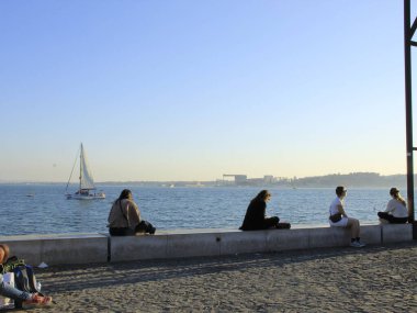 İnsanlar Lizbon 'da güneşli bir günün tadını çıkarıyor. 27 Ekim 2021, Lizbon, Portekiz: İnsanlar 27 Çarşamba günü Lizbon 'da Tejo Nehri kıyısında, Cais do Sodre ve Comercio Meydanı arasında güneşli bir Avrupa sonbahar öğleden sonrasının keyfini çıkarıyorlar.). 