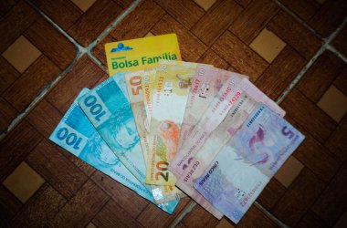 Gerçek banknotların ve Bolsa Aile Sosyal Programı kartının resimli görüntüsü. 22 Kasım 2021, Sao Paulo, Brezilya. Hükümet tarafından oluşturulan Bolsa Aile Sosyal Programı 'ndan gerçek banknotların ve kartların tasviri. 