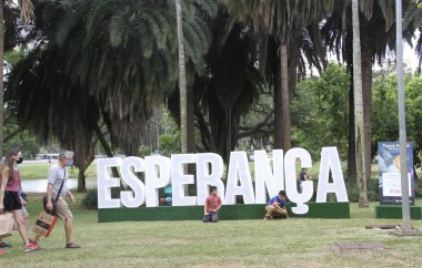 Güneşli bir günde kalabalık bir Ibirapuera Parkı. 5 Aralık 2021, Sao Paulo, Brezilya: Güneşli bir günde, Sao Paulo 'daki Ibirapuera Parkı' nda, Covid-19, Omicron 'un yeni varyasyonunun ortasında ağır bir insan hareketi var. İnsanların çoğu yüz maskesi takıyor.