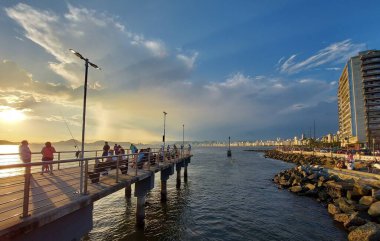 Bathers enjoy the sunset in Santos. January 16, 2022, Santos, Sao Paulo, Brazil: Bathers enjoy the sunset at Ponta da Praia and Deck do Pescador, in Santos, on the south coast of Sao Paulo, on Sunday (16), with intense heat in the Santos 