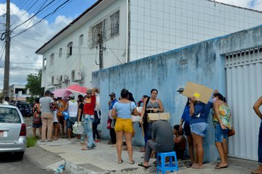 İnsanlar Natal 'daki Auxilio Brasil gibi sosyal hizmetler ve programlar için uzun kuyruklar oluştururlar. 21 Ocak 2022, Natal, Rio Grande de Sul, Brezilya: Natal 'dan düzinelerce insan geceyi Sosyal Yardım Referansı önünde kuyrukta geçirdi 