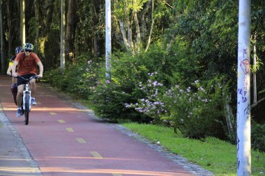 Curitiba şehrindeki bir bisiklet yolunda bisikletçilerin hareketi. 11 Şubat 2022, Curitiba, Parana, Brezilya: Parana 'nın başkenti Curitiba' ya yayılan çok sayıda ortak bisiklet yolunun birinde bisikletçilerin hareketi (11) Cuma günü)