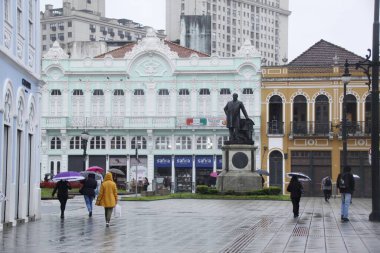 Curitiba şehrinde soğuk ve yağmurlu bir öğleden sonra. 1 Nisan 2022, Curitiba, Parana, Brezilya: Yayalar Cuma (1) günü Curitiba, Parana 'da çiseleme ve düşük sıcaklık altında yürürler.). 