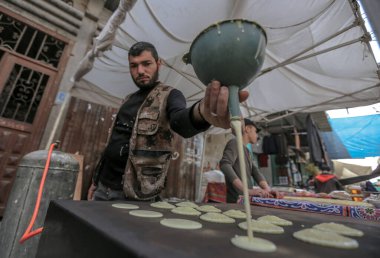 Filistinliler kutsal Ramazan ayı boyunca Gazze 'de alışverişe giderler. 4 Nisan 2022, Gazze, Filistin: Filistinliler 4 Pazartesi günü Gazze Şeridi 'nin güneyindeki Han Yunus kampında kutsal Ramazan ayında alışverişe gidiyorlar.) 