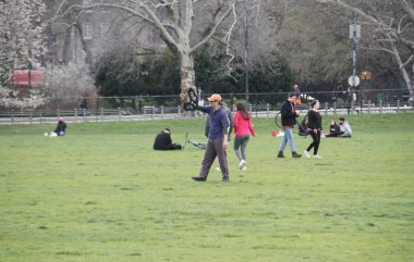 Central Park 'ın büyük çimleri halka açıldı. 11 Nisan 2022, New York, ABD: Salgın döneminde Central Park 'ın büyük bahçesi kapatıldıktan sonra halka açıldı. Çok az insan piknik yaparken, müzik dinlerken görülüyor.