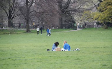 Central Park 'ın büyük çimleri halka açıldı. 11 Nisan 2022, New York, ABD: Salgın döneminde Central Park 'ın büyük bahçesi kapatıldıktan sonra halka açıldı. Çok az insan piknik yaparken, müzik dinlerken görülüyor.