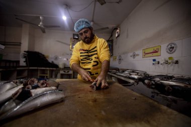 Filistinli tütsülenmiş ringa balığı ve tuzlanmış balığı Gazze 'de satılığa çıkarttı. 1 Nisan 2022, Gazze, Filistin: Filistinliler Maghazi mülteci kampındaki bayram tatilinden günler önce tütsülenmiş ringa balığı ve tuzlanmış balığı pazarlarda satmak için hazırlıyorlar.