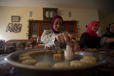 Filistinli kadınlar bayram hazırlığı için içi tarihlerle doldurulmuş pastalar yapıyorlar. 1 Mayıs 2022, Gazze Şeridi, Filistin: Filistinli kadınlar bayram hazırlıkları için tarihlerle doldurulmuş pastalar yapıyorlar 