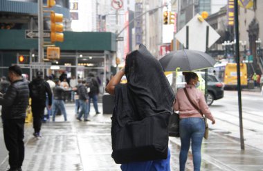 Times Meydanı 'nda yağmur altında. 6 Mayıs 2022, New York, ABD: New Yorklular ve turistler Cuma günü Times Meydanı 'nda yağış ile karşı karşıya kalırken, hava tahminleri tüm gün boyunca% 90 ila 98 arasında, 57F' ye kadar yağmur yağacağını söylüyor (yaklaşık 13.8C).).