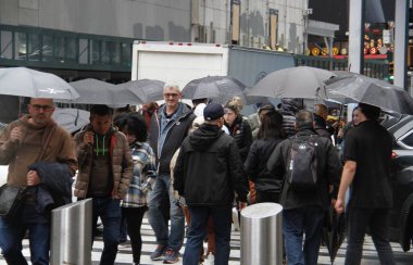 Times Meydanı 'nda yağmur altında. 6 Mayıs 2022, New York, ABD: New Yorklular ve turistler Cuma günü Times Meydanı 'nda yağış ile karşı karşıya kalırken, hava tahminleri tüm gün boyunca% 90 ila 98 arasında, 57F' ye kadar yağmur yağacağını söylüyor (yaklaşık 13.8C).).