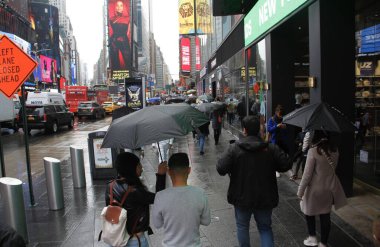 Times Meydanı 'nda yağmur altında. 6 Mayıs 2022, New York, ABD: New Yorklular ve turistler Cuma günü Times Meydanı 'nda yağış ile karşı karşıya kalırken, hava tahminleri tüm gün boyunca% 90 ila 98 arasında, 57F' ye kadar yağmur yağacağını söylüyor (yaklaşık 13.8C).).