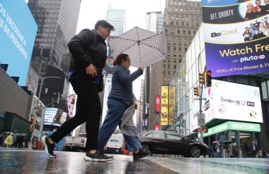 Times Meydanı 'nda yağmur altında. 6 Mayıs 2022, New York, ABD: New Yorklular ve turistler Cuma günü Times Meydanı 'nda yağış ile karşı karşıya kalırken, hava tahminleri tüm gün boyunca% 90 ila 98 arasında, 57F' ye kadar yağmur yağacağını söylüyor (yaklaşık 13.8C).).