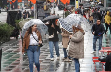 Times Meydanı 'nda yağmur altında. 6 Mayıs 2022, New York, ABD: New Yorklular ve turistler Cuma günü Times Meydanı 'nda yağış ile karşı karşıya kalırken, hava tahminleri tüm gün boyunca% 90 ila 98 arasında, 57F' ye kadar yağmur yağacağını söylüyor (yaklaşık 13.8C).).