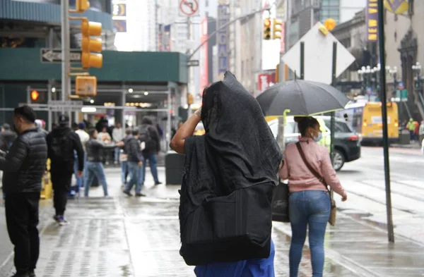 Times Meydanı 'nda yağmur altında. 6 Mayıs 2022, New York, ABD: New Yorklular ve turistler Cuma günü Times Meydanı 'nda yağış ile karşı karşıya kalırken, hava tahminleri tüm gün boyunca% 90 ila 98 arasında, 57F' ye kadar yağmur yağacağını söylüyor (yaklaşık 13.8C).).