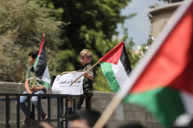 Palestinians wave flags during march for 74th anniversary of 