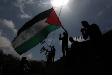 Palestinians wave flags during march for 74th anniversary of 