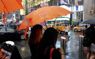 Times Meydanı 'nda New Yorklular Yağmur Altında. 21 Haziran 2022, New York, ABD: New Yorklular ve turistler Times Meydanı 'nda kısa ve hafif bir yağmura maruz kaldılar ve hepsi şemsiyelerden korunmak zorunda kalarak eğlenmek zorunda kaldılar