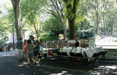 Central Park 'ta güneşli bir gün. 19 Temmuz 2022, New York, ABD: Bazıları Central Park 'ı gezerken, müzik dinlerken, kürek çekerken, resim çekerken, spor yaparken ve hatta kaplumbağaları beslerken görülüyor. 