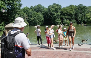 Central Park 'ta güneşli bir gün. 19 Temmuz 2022, New York, ABD: Bazıları Central Park 'ı gezerken, müzik dinlerken, kürek çekerken, resim çekerken, spor yaparken ve hatta kaplumbağaları beslerken görülüyor. 