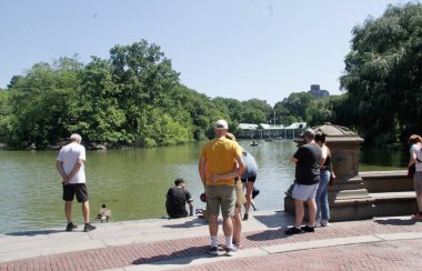 Central Park 'ta güneşli bir gün. 19 Temmuz 2022, New York, ABD: Bazıları Central Park 'ı gezerken, müzik dinlerken, kürek çekerken, resim çekerken, spor yaparken ve hatta kaplumbağaları beslerken görülüyor. 