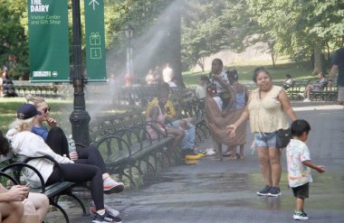 İnsanlar Central Park 'taki kırık bir borudan suyla ıslanarak faydalanıyor. 28 Temmuz 2022, New York, ABD: 87F 'ye ulaşan sıcak ve sıcak hava nedeniyle, insanlar Central Park' taki kırık bir borudan faydalanıyorlar