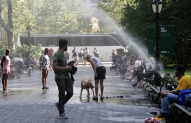 İnsanlar Central Park 'taki kırık bir borudan suyla ıslanarak faydalanıyor. 28 Temmuz 2022, New York, ABD: 87F 'ye ulaşan sıcak ve sıcak hava nedeniyle, insanlar Central Park' taki kırık bir borudan faydalanıyorlar