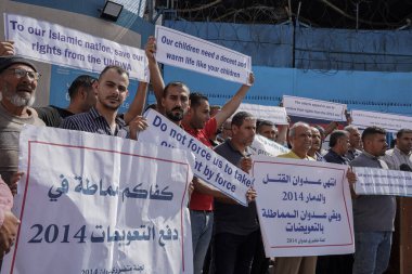 Filistinliler, Gazze 'deki UNRWA karargahının önünde oturma eylemi düzenliyor. 16 Ekim 2022 2014 'teki Gazze Şeridi saldırısından etkilenen çok sayıda Filistinli UNRWA genel merkezi önünde barışçıl bir oturma eylemine katıldı.