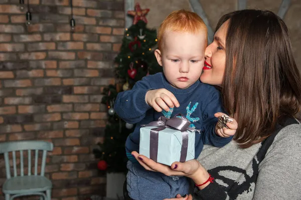 Mutlu anne ve tapılası bebeğin portresi Noel 'i kutluyor. Yeni yıl tatili. Annenle birlikte Noel ağacı ve süslemelerle süslenmiş bir odada..