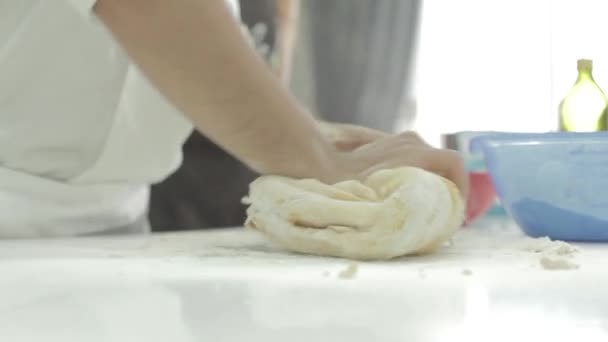 Baker está amassando a massa na farinha na mesa em câmera lenta. Não há pessoas só mãos . — Vídeo de Stock