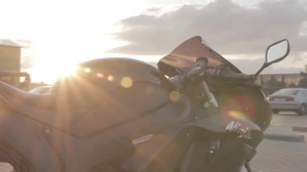 Zwarte motorfiets in fel zonlicht close-up — Stockvideo