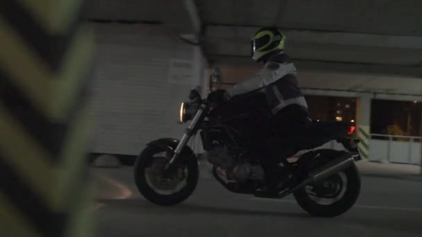 Motorcyklist rider på parkeringen på natten — Stockvideo