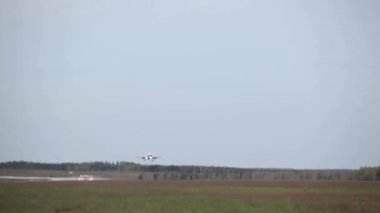 Uçak, ormanın arka planına karşı kalkıyor.