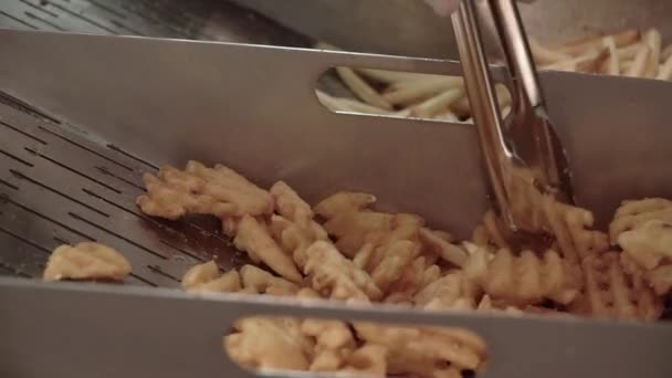 Fast Food, Cooking Fries Potato. A human takes french fries with tongs — Stock Video