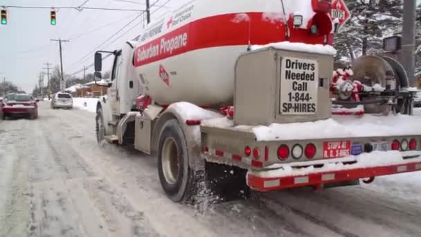 Sur une route enneigée Le camion rouge américain transporte du propane de banlieue. — Video