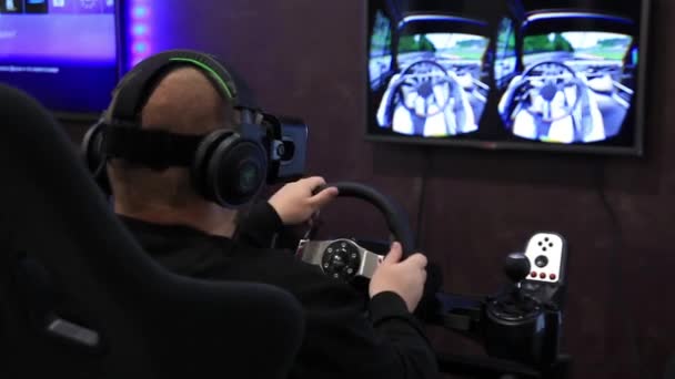 Un jeune homme joue à un jeu de course et porte des lunettes de réalité virtuelle — Video