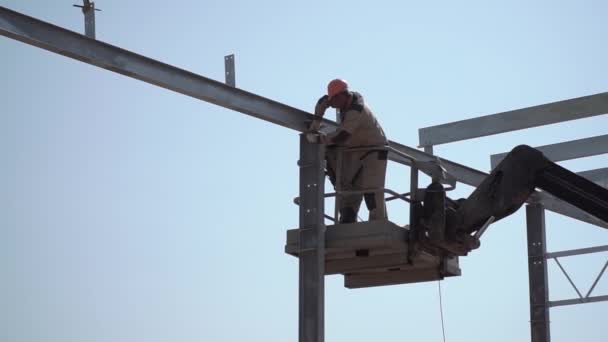 La plataforma aérea levanta al trabajador que aprieta el perno con una llave de metal. obras en altura — Vídeos de Stock