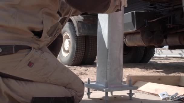 Un ouvrier de la construction serre un boulon avec une clé en métal. vue arrière rapprochée. — Video