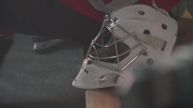 Hokey kaskı bankta yatıyor. Kış sporu kavramı. Alan ve arkaplan videosunu kopyala. Spor kıyafetleri ve ekipmanlar..