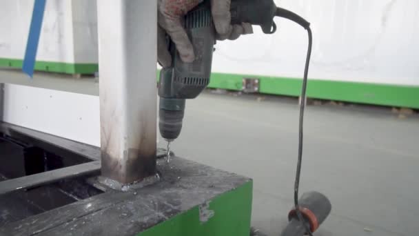Un trabajador perfora un agujero en una parte metálica. — Vídeo de stock