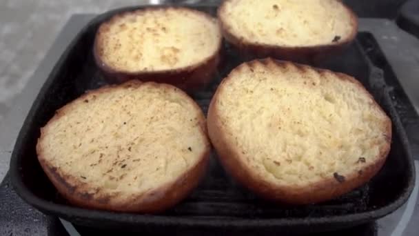 Νόστιμα ψωμάκια για μπιφτέκια τηγανίζονται στο πλέγμα της σχάρας — Αρχείο Βίντεο