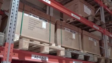 Büyük fabrika deposu. Dükkan koridorları. Kamera büyük bir mağazanın içinde döner. Depoya teslimat var. Kutuları ve malları taşımak için forklift kullanan lojistik işleri ve aracı. kargo posta endüstrisi