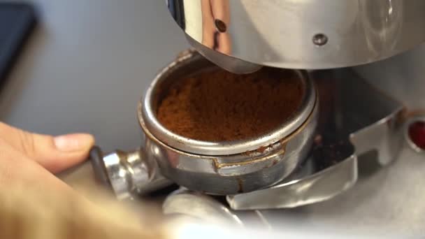 Profesyonel barista işçisi kahve dükkanında sıcak içecek yapmak için öğütücü makinesini kullanır.. — Stok video