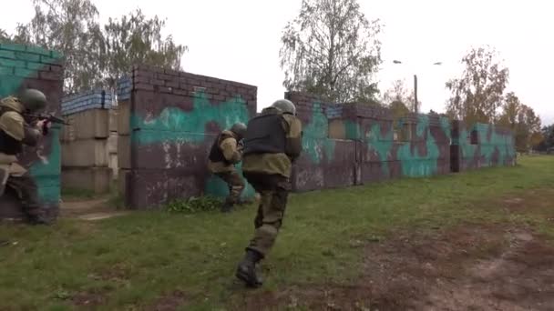 Un soldat dans un casque avec une arme courant pour se couvrir. Enseignements sur le terrain d'entraînement militaire. — Video
