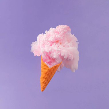 Portakallı dondurma külahı ve mor arka planda pastel pembe boya. Asgari soyut yaz konsepti. Yaratıcı tatlı yemek sürrealite kompozisyonu.