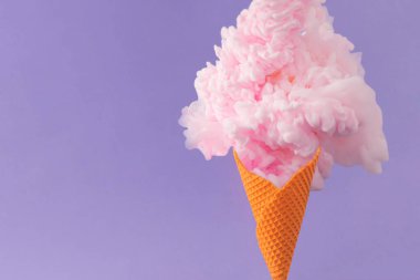 Portakallı dondurma külahı ve mor arka planda pastel pembe boya. Asgari soyut yaz konsepti. Gerçeküstü yaratıcı tatlı yemeği fikri.