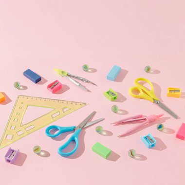 Trendy bright pink background with colorful school supplies. Creative back to school concept with copy space. Learning idea.